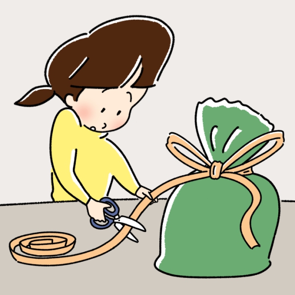 女の子がプレゼントのリボンをはさみで切るところ